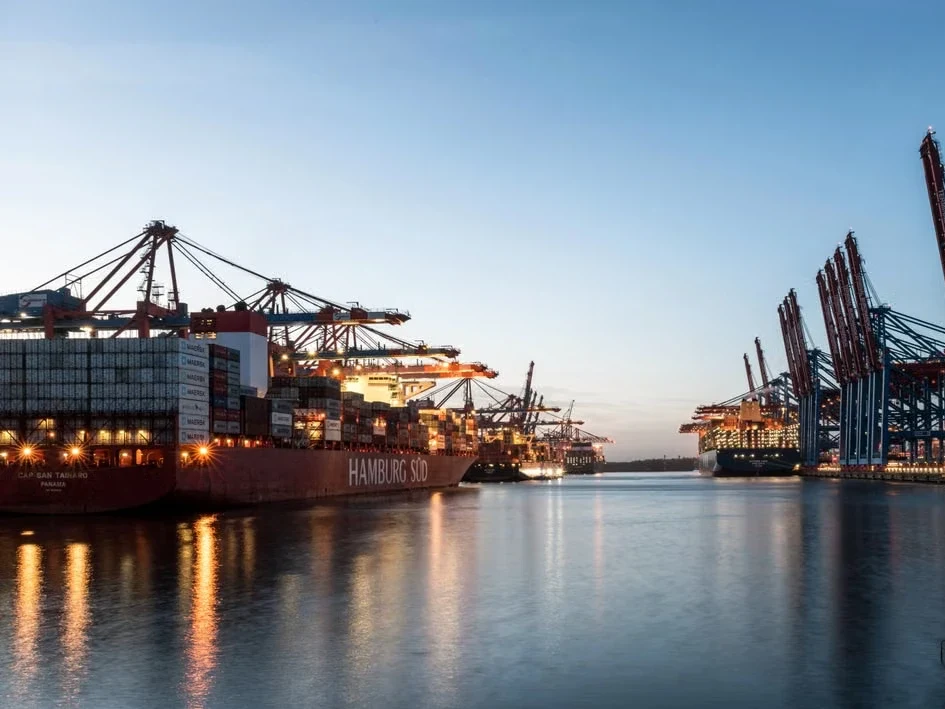 Container ship being loaded at a port terminal at dusk
